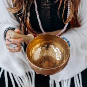 A woman holding a singing bowl, engaging in a peaceful meditation practice.